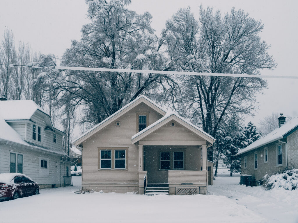 A beige house covered in snow.