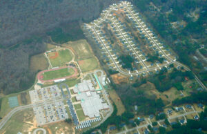 Aerial view of a high school, parking lot, and adjacent neighborhood