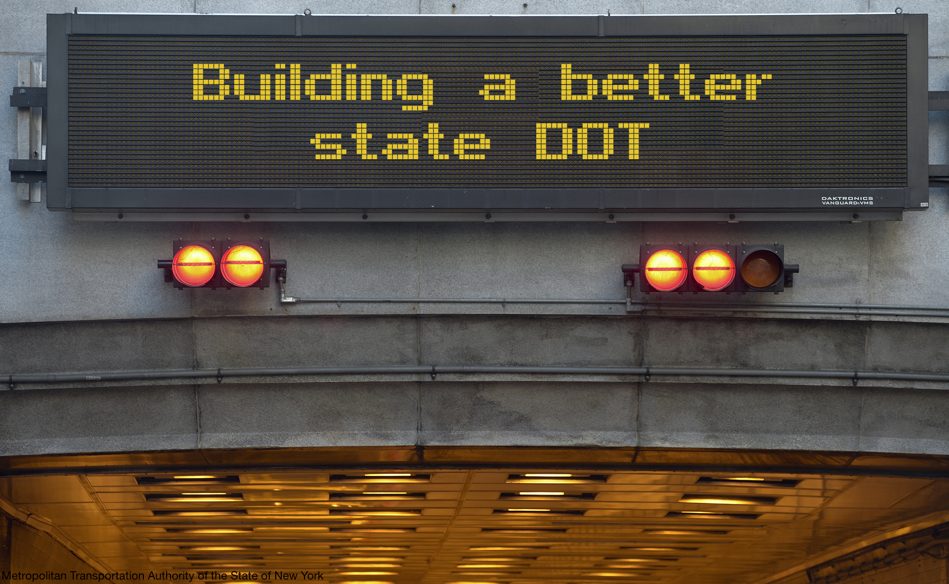 a variable traffic message board above a tunnel that reads Building a better state DOT