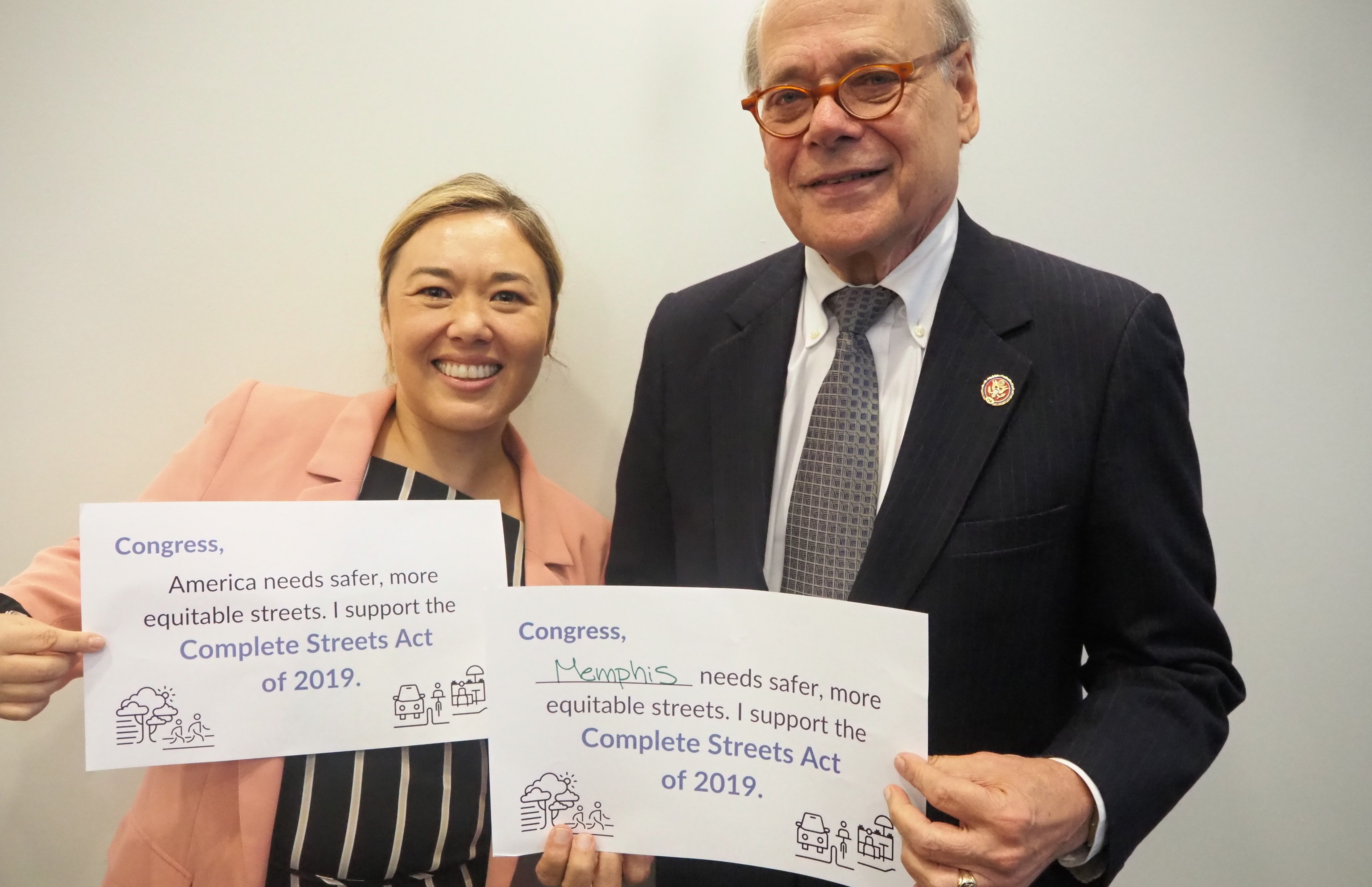 Emiko Atherton, director of the National Complete Streets Coalition and Rep. Steve Cohen holding signs supporting the Complete Streets Act.