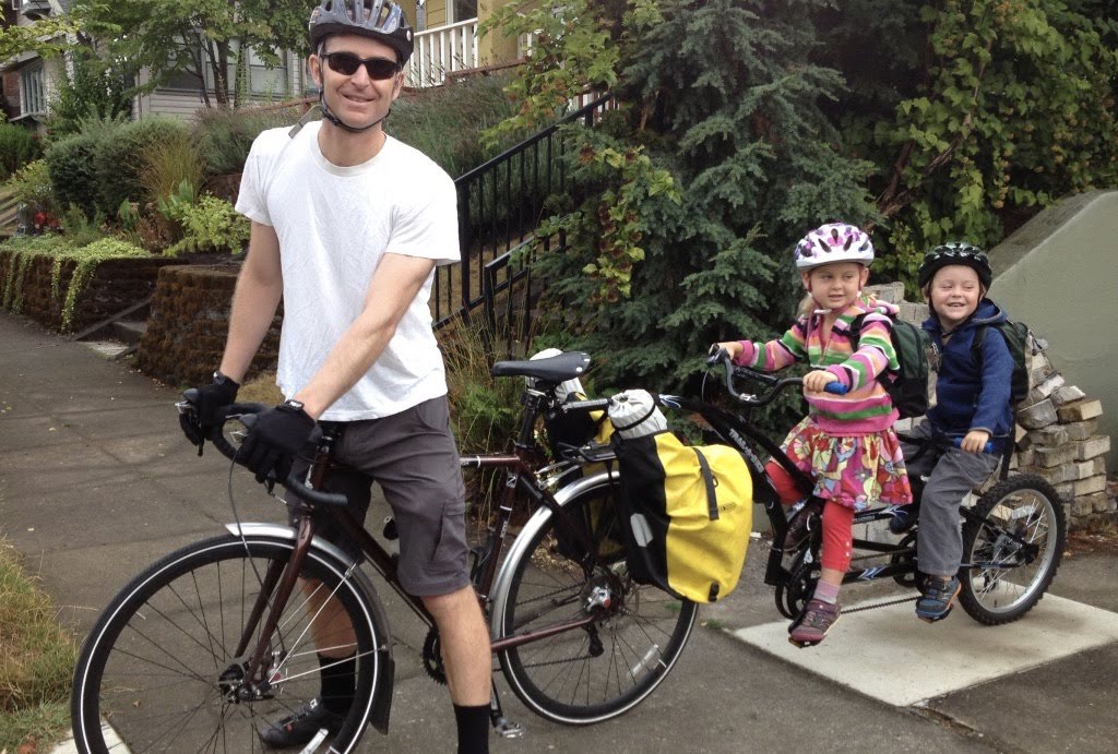 Chris Rall and his two twins pictured on a bike.