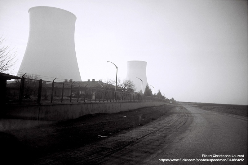 black and white photo of a nuclear power plant with cooling towers shrouded in mist