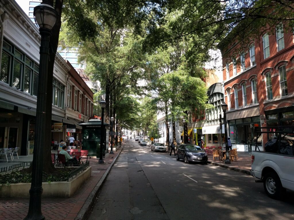a beautiful tree lined downtown street in Atlanta with 2-5 story mixed use historic buildings
