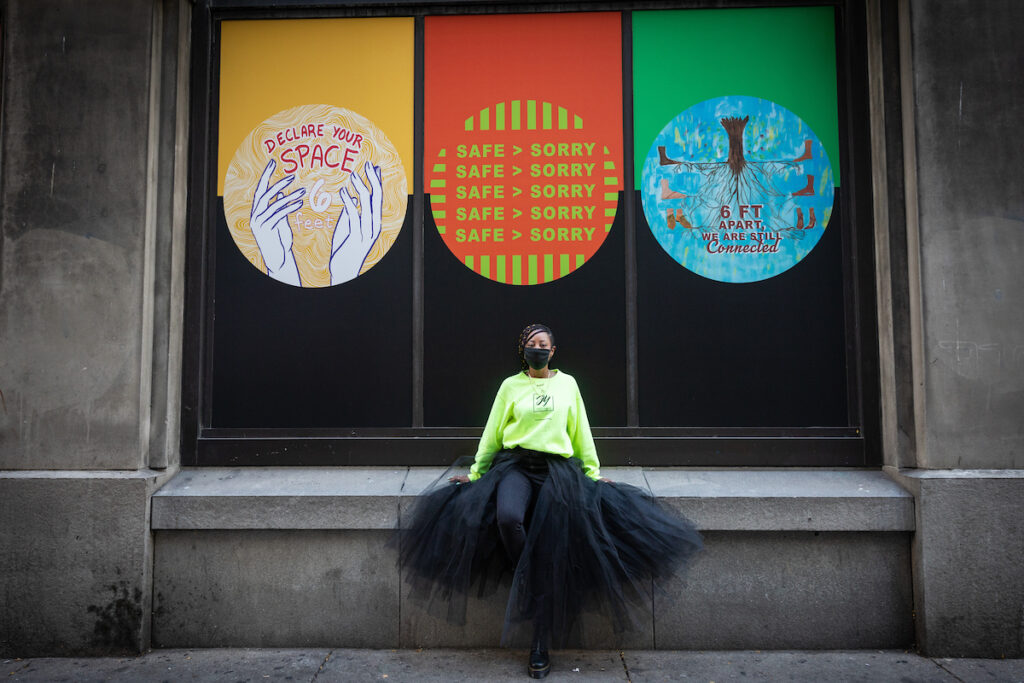 Artist Janel Young standing in front of her artwork in Pittsburgh, PA.