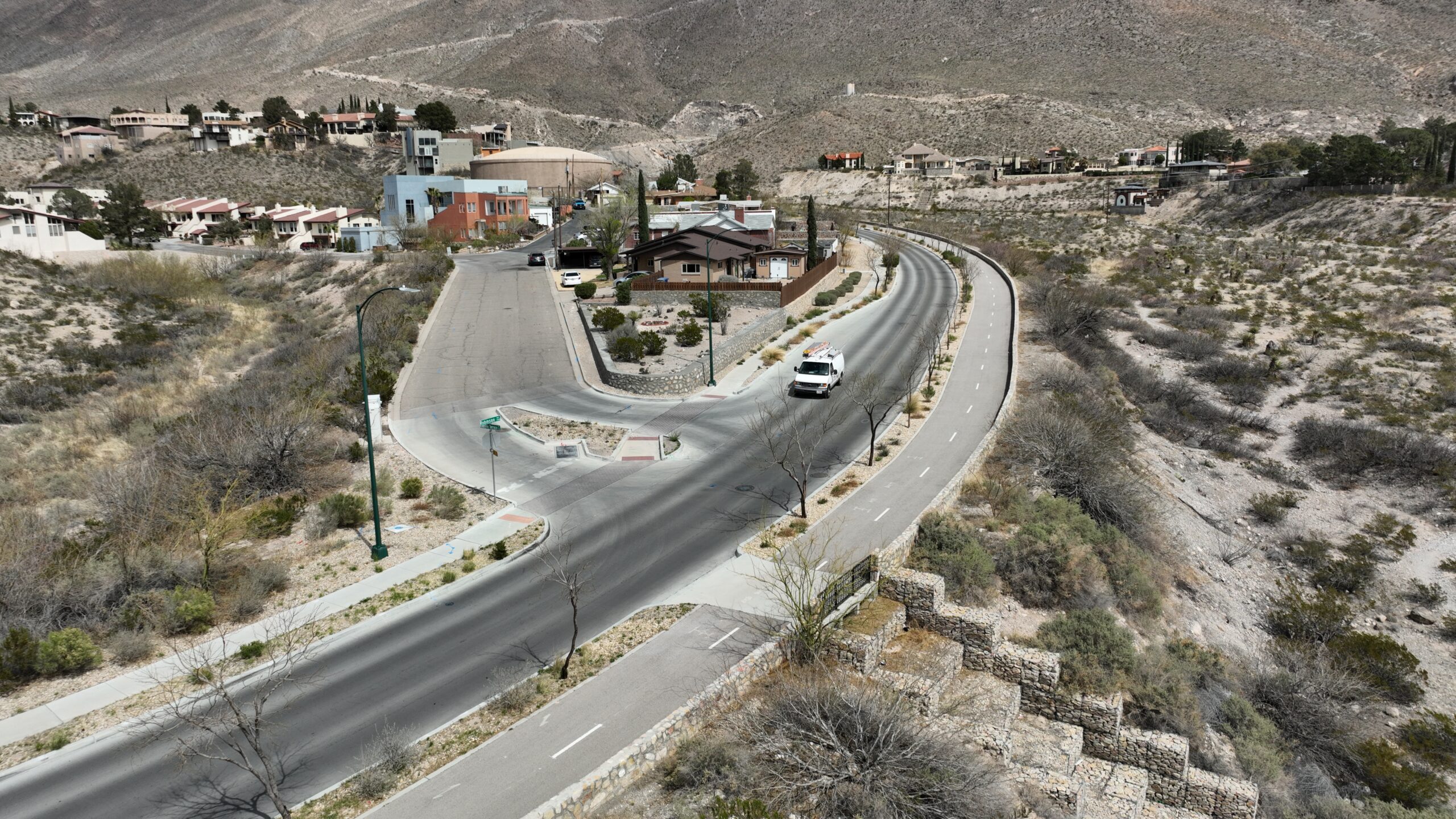An elevated view of a two-lane shared-use path next to a two lane road with mountains in the background