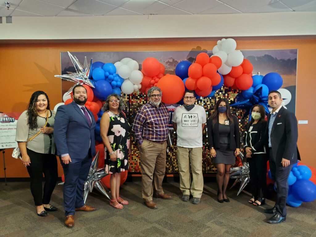 Members of the Complete Streets Coalition against a wall in front of balloons after passage of the policy