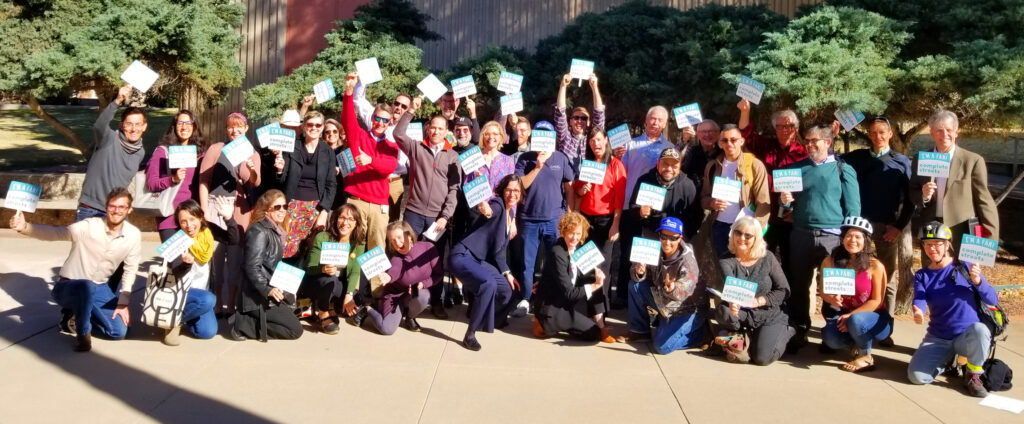 Supporters and members of Living Streets Alliance lined up outside holding signs in support of Complete Streets.