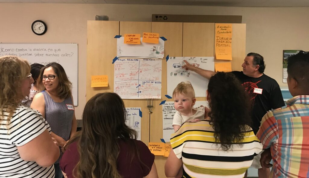 Community members pointing and talking during a dialogue session.