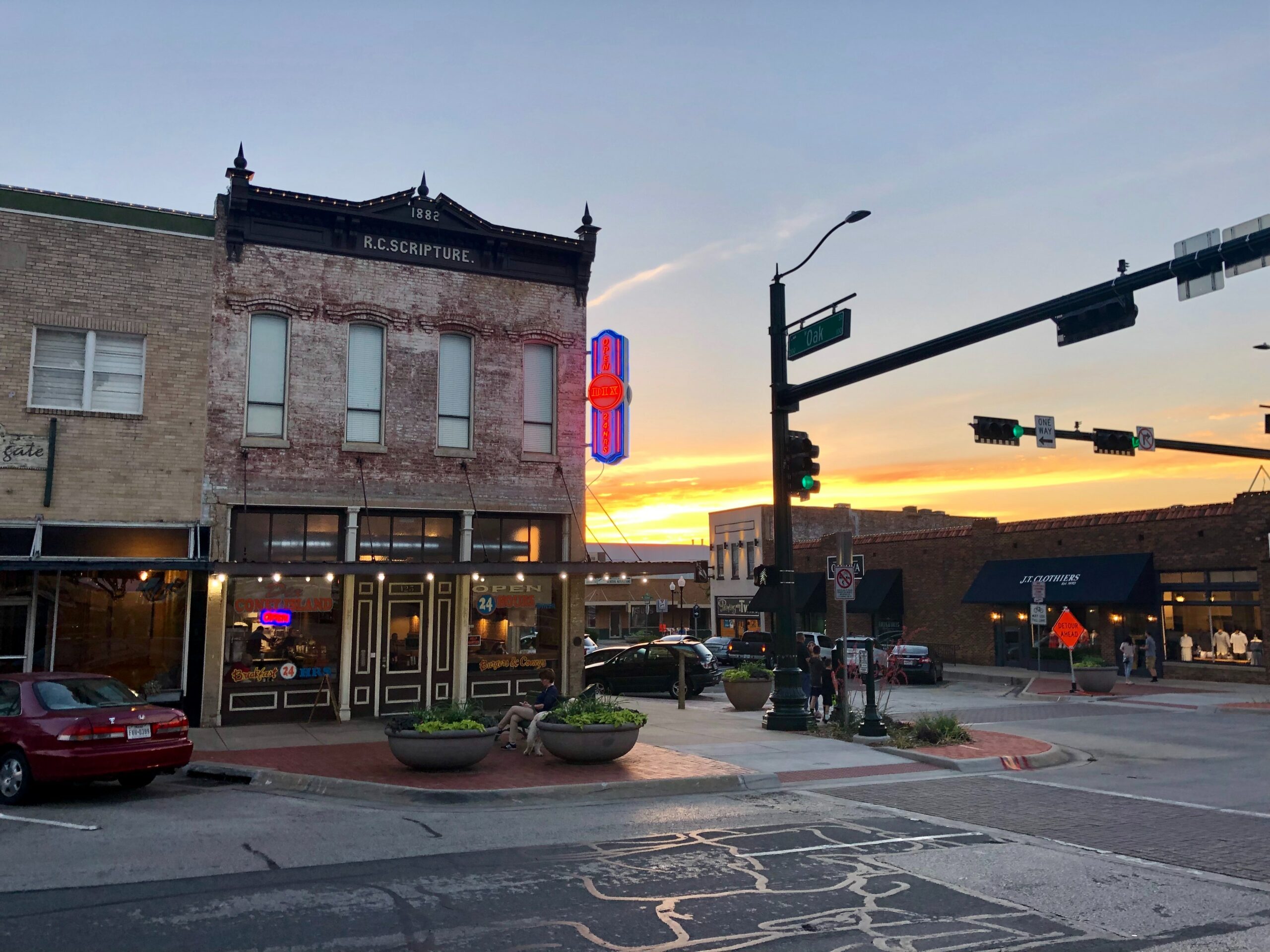 The sun sets behind a brick store in Denton, TX
