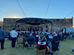 As the sun sets, Clarksville's Levee Park comes alive as people gather in front of a stage for an evening event.