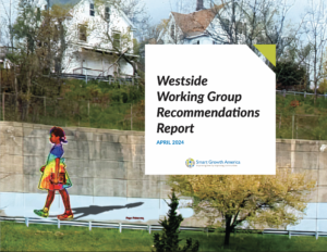 A mural of a girl in a rainbow dress on a wall in Pittsfield with a report title that reads "Westside Working Group Recommendations Report"