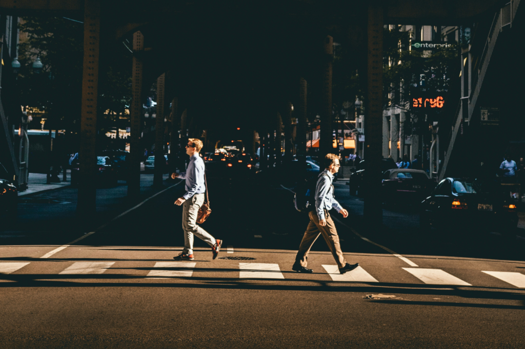 Two men in business attire cross the street