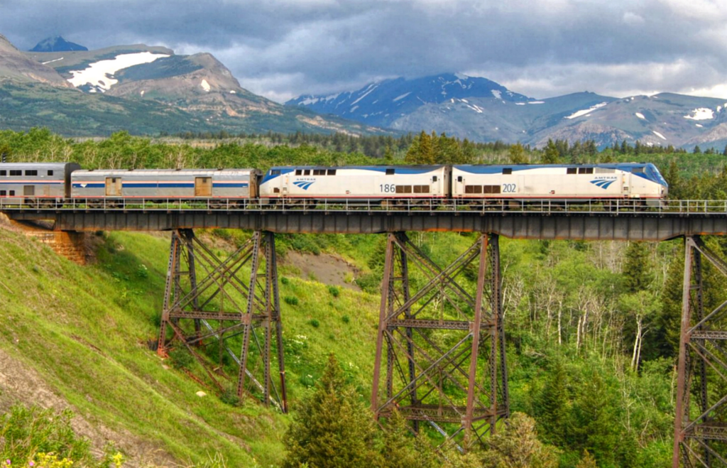 A train crosses a valley between mountains