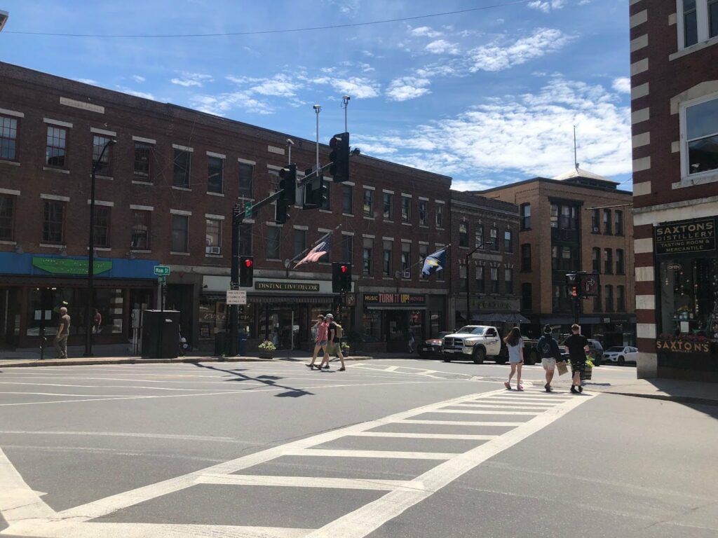 Pedestrians walk across a four-way intersection that includes diagonal crosswalks